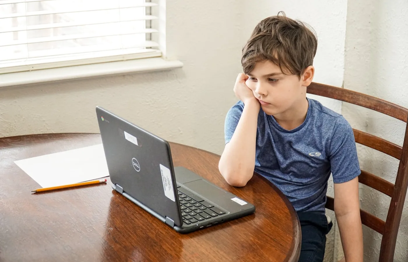 Uczeń znudzony i zniechęcony nauką przy laptopie