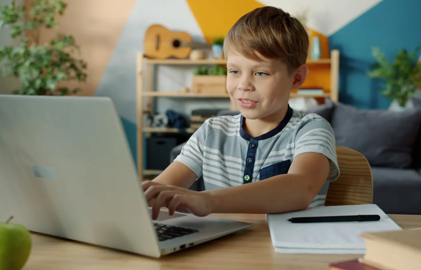 Uczeń uśmiechnięty przy laptopie podczas lekcji online w Eduloop